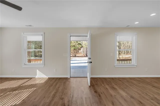 a view of empty room with wooden floor