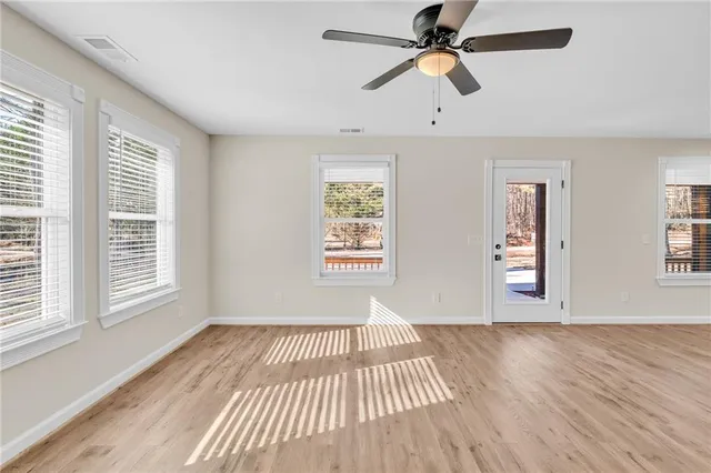 a large white kitchen with kitchen island a sink wooden floor and a refrigerator