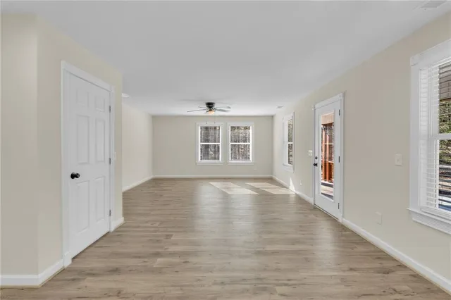 a view of a hallway with wooden floor and a bathroom