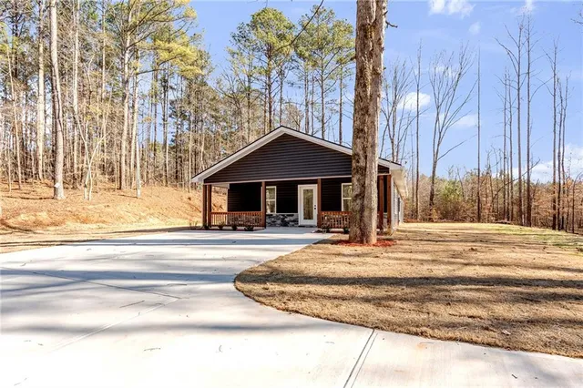 a front view of a house with a yard and trees