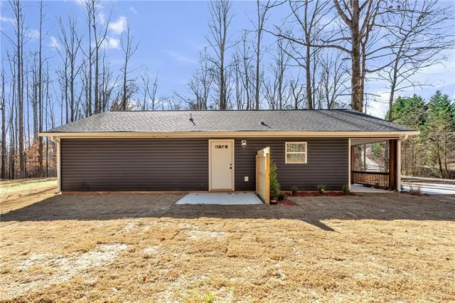 a front view of a house with a yard covered in snow