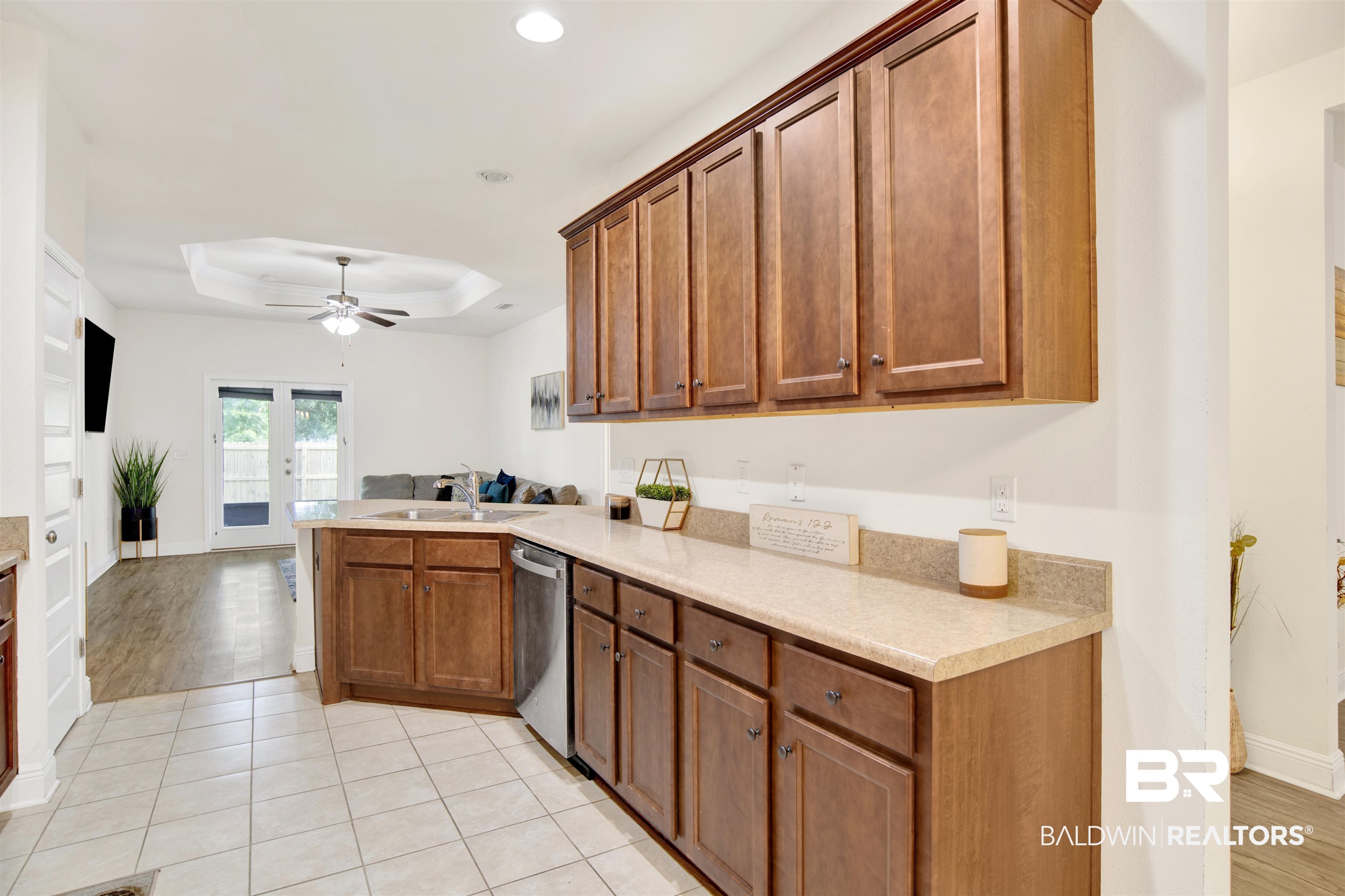 1468 Surrey Loop Foley, AL 36535 - Photo 9 of 28 Kitchen featuring dishwasher, a sink, a peninsula, a ceiling fan, and a tray ceiling