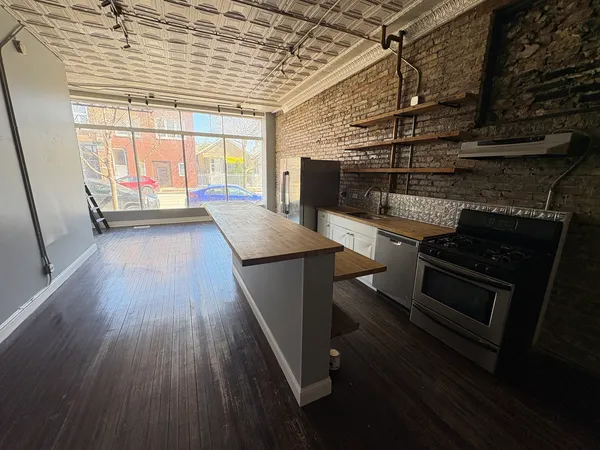 a kitchen with a wooden floor and a stove top oven