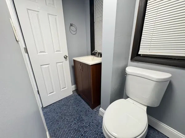 a white toilet sitting next to a sink and vanity