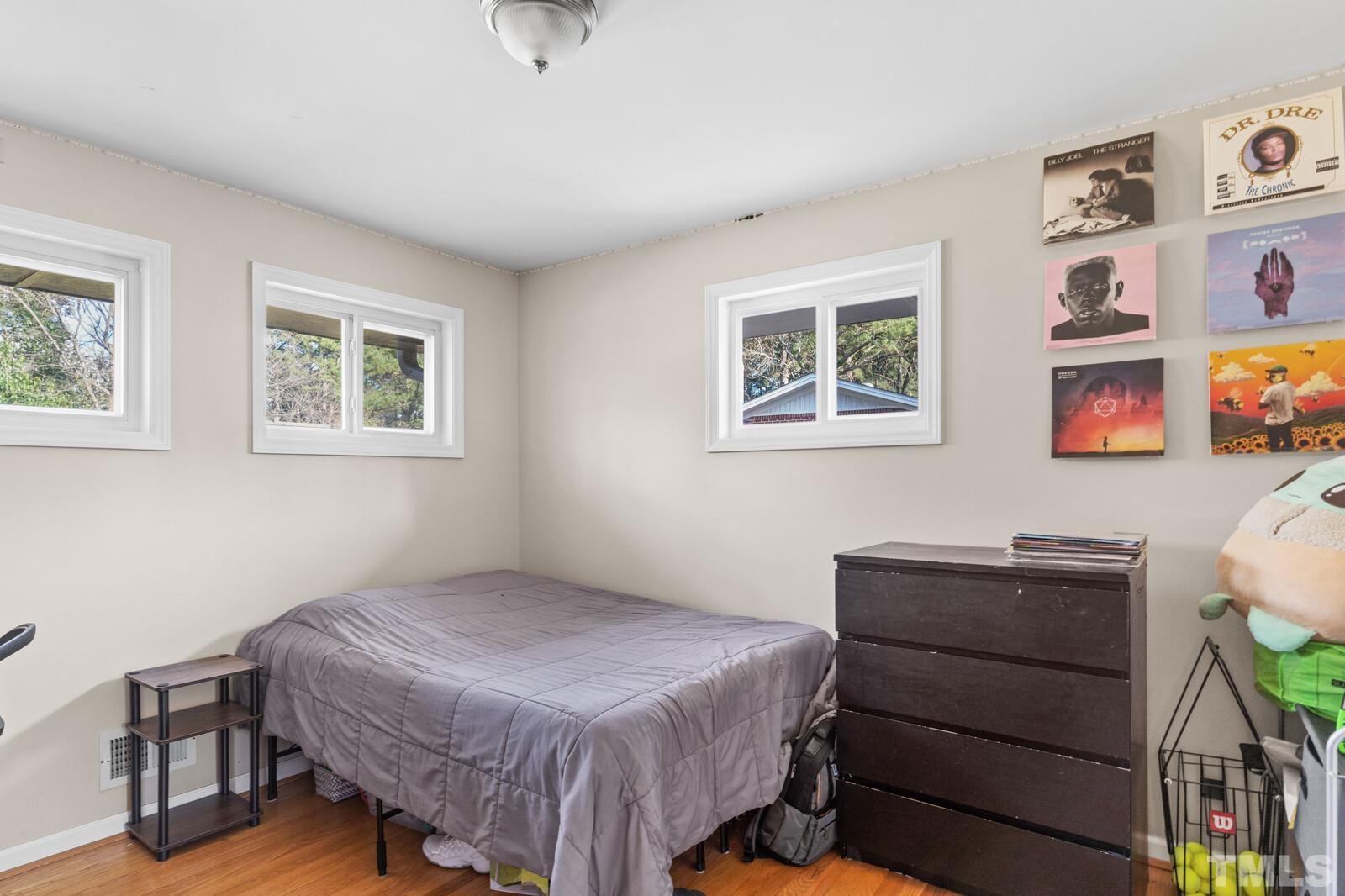 827 Athens Drive Raleigh, NC 27606 - Photo 12 of 34 a bedroom with a bed and a dresser