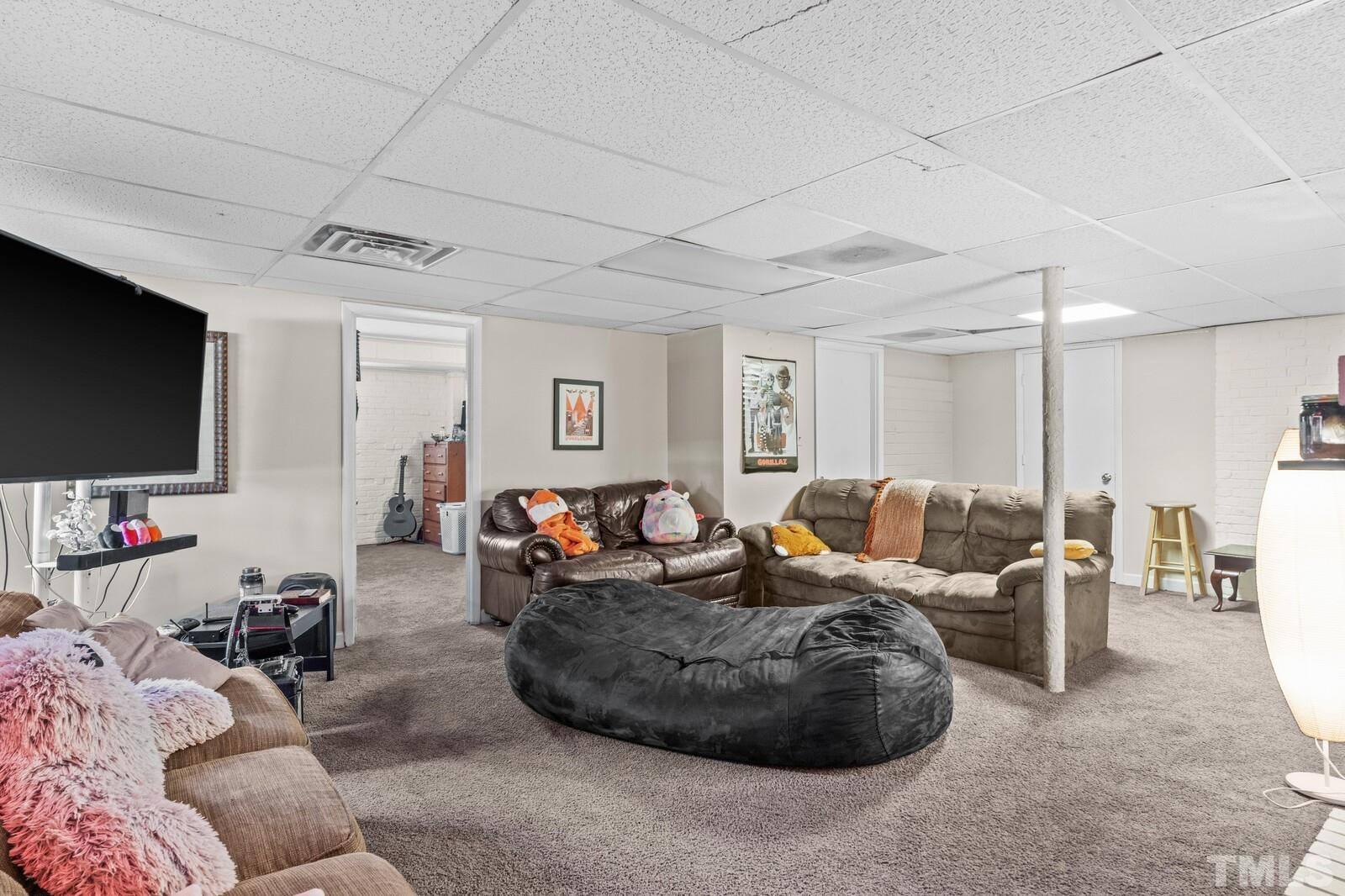 827 Athens Drive Raleigh, NC 27606 - Photo 17 of 34 a living room with furniture and a flat screen tv