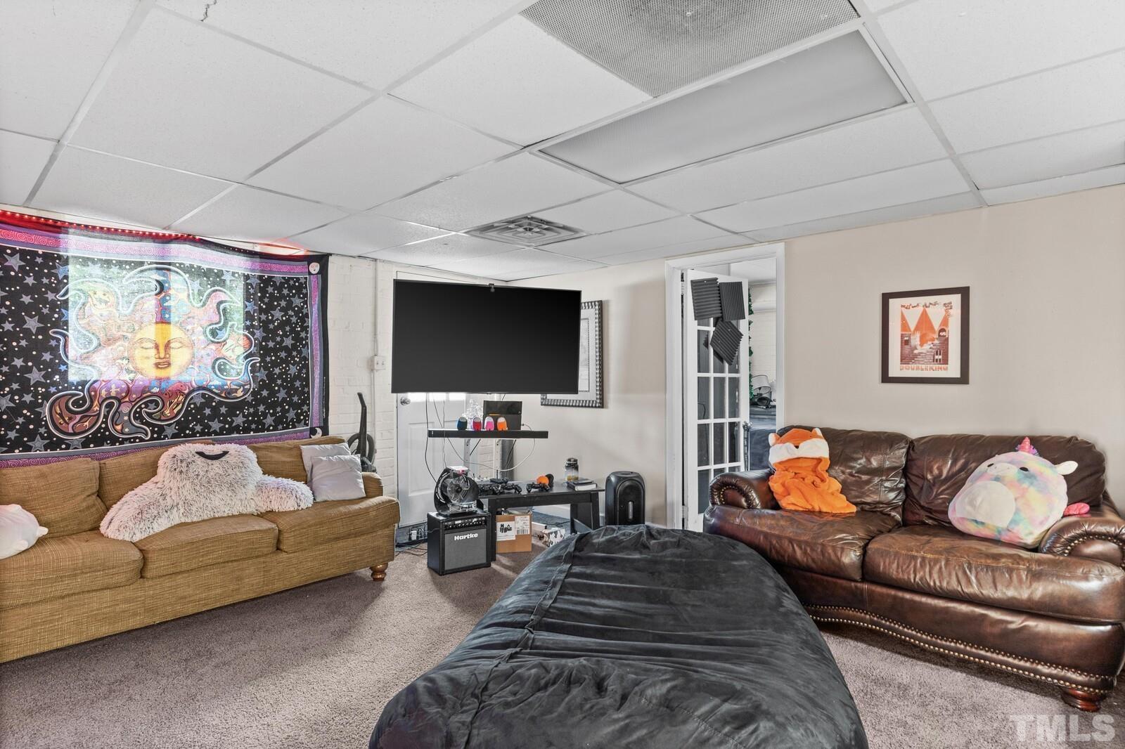 827 Athens Drive Raleigh, NC 27606 - Photo 18 of 34 a living room with furniture and a flat screen tv