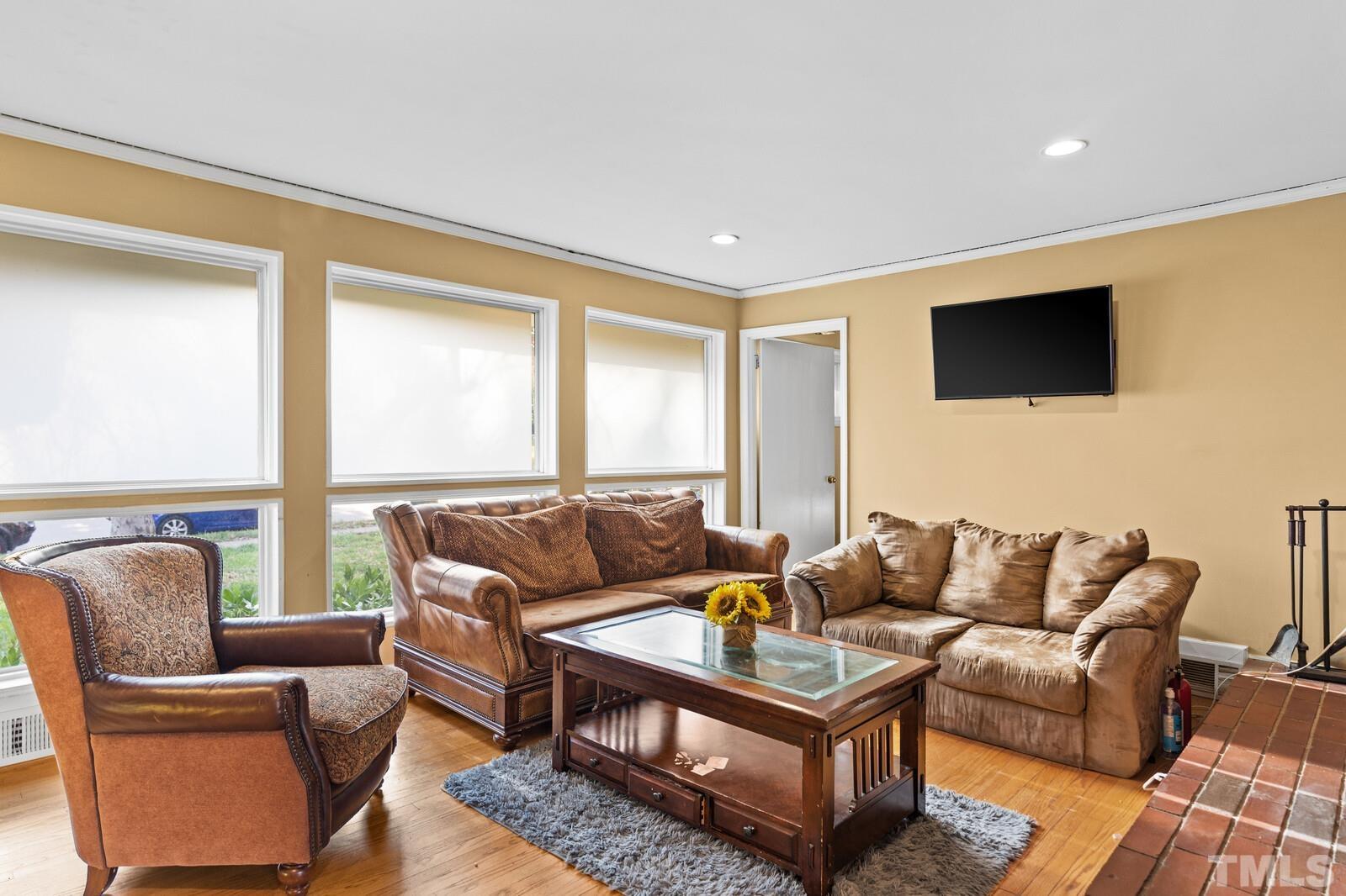 827 Athens Drive Raleigh, NC 27606 - Photo 4 of 34 a living room with furniture and a flat screen tv