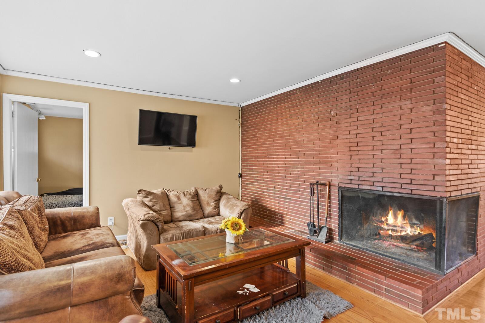827 Athens Drive Raleigh, NC 27606 - Photo 5 of 34 a living room with furniture and a fireplace
