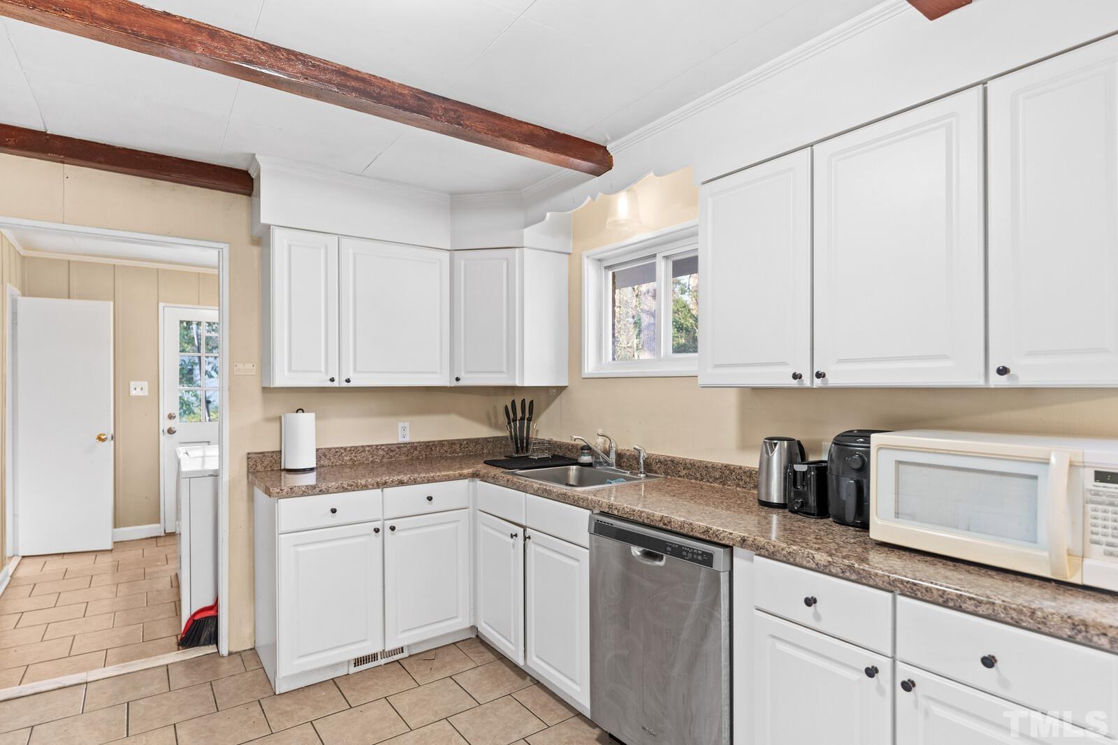 827 Athens Drive Raleigh, NC 27606 - Photo 8 of 34 a kitchen with granite countertop white cabinets and white appliances