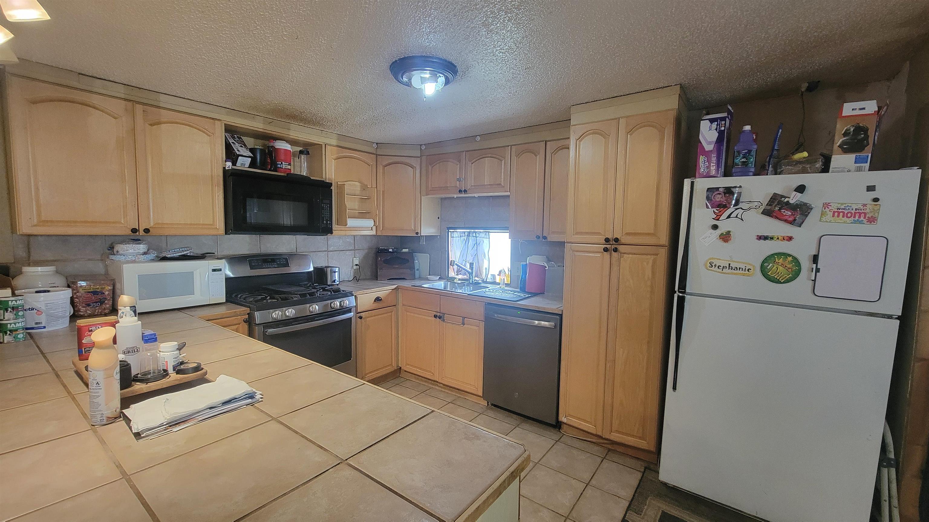 1844 M Road Fruita, CO 81521 - Photo 17 of 32 a kitchen with a refrigerator a stove a sink a dining table and chairs with wooden floor