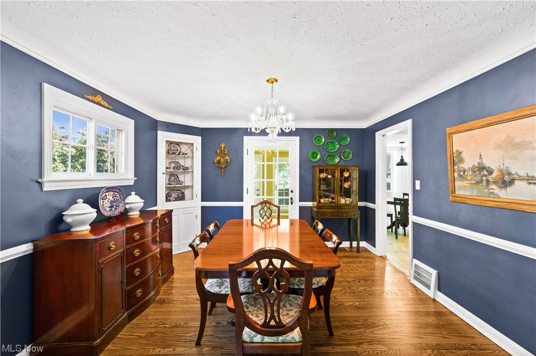 15722 Munn Road Cleveland, OH 44111 - Photo 6 of 32 Dining room featuring a notable chandelier, plenty of natural light, light hardwood floors, and a textured ceiling