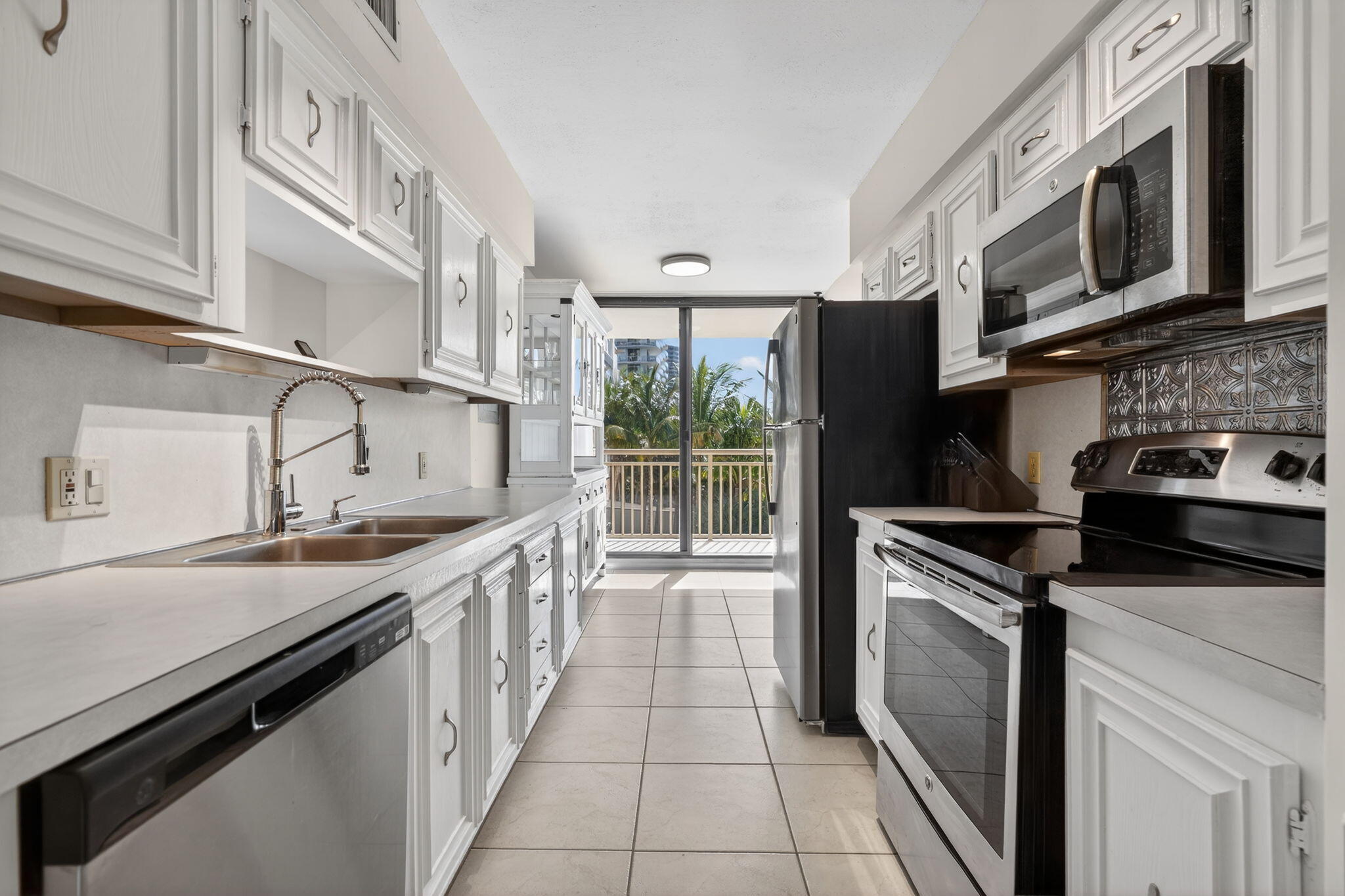 3400 North Ocean Drive, Unit 408 Singer Island, FL 33404 - Photo 5 of 31 a kitchen with stainless steel appliances granite countertop a sink stove and microwave