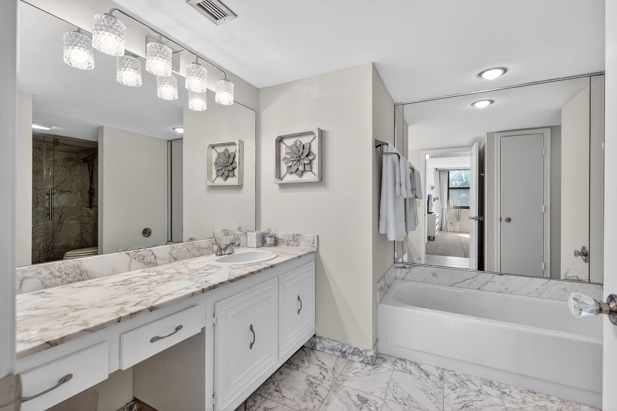 3400 North Ocean Drive, Unit 408 Singer Island, FL 33404 - Photo 8 of 31 a spacious bathroom with a granite countertop sink a toilet a mirror a bathtub and shower