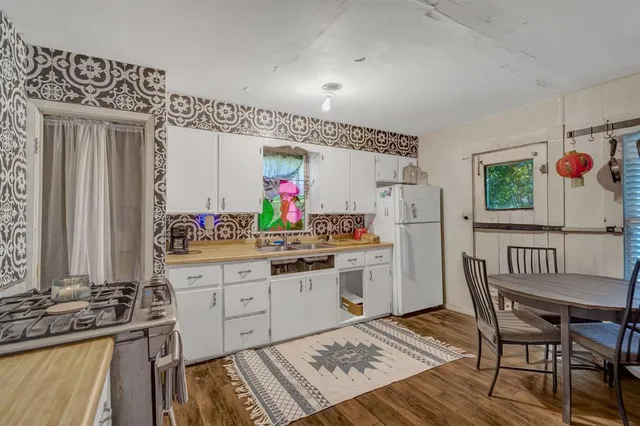 a kitchen view with a refrigerator and wooden floor