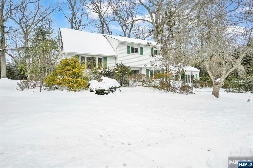 645 Wildwood Road West Northvale, NJ 07647 - Photo 2 of 35 a front view of a house with a yard covered in snow