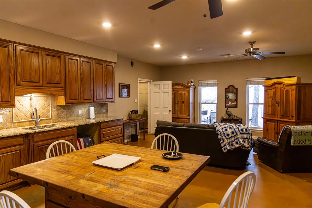 2946 Fm 52 Graford, TX 76449 - Photo 39 of 40 a kitchen with stainless steel appliances granite countertop a stove refrigerator a sink dishwasher a dining table and chairs with wooden floor