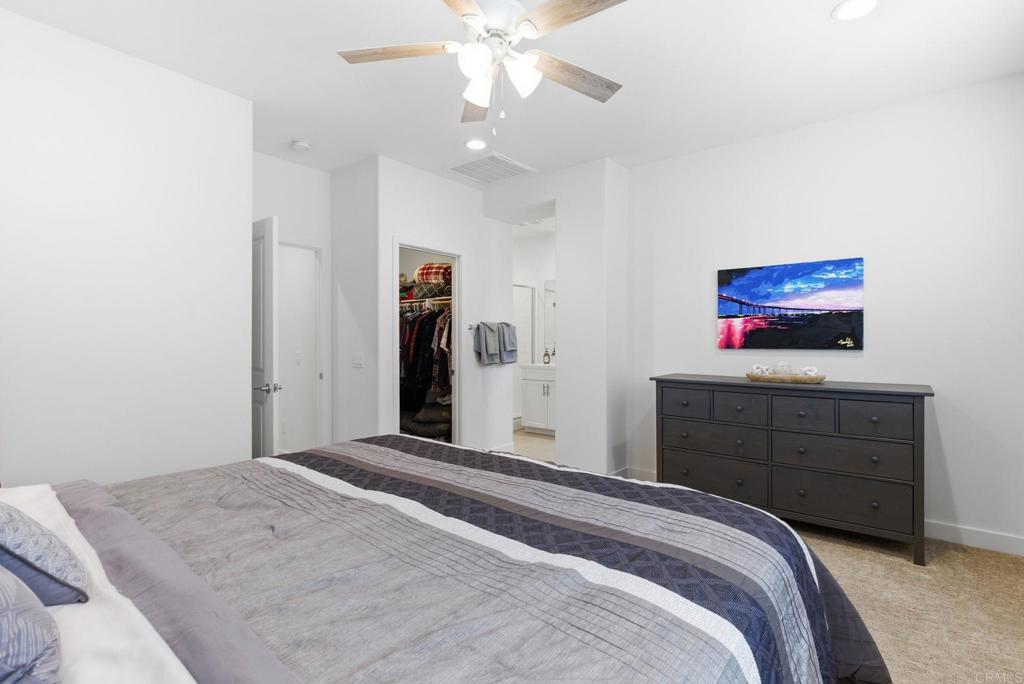 4367 Pacifica Way, Unit 2 Oceanside, CA 92056 - Photo 23 of 37 a bedroom with a large bed a chandelier and a dresser