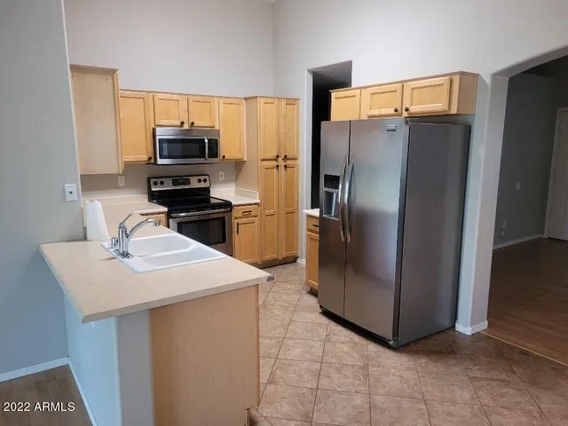 a kitchen with stainless steel appliances a refrigerator sink and microwave