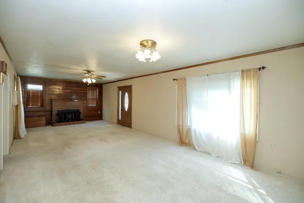 an empty room with closet and windows