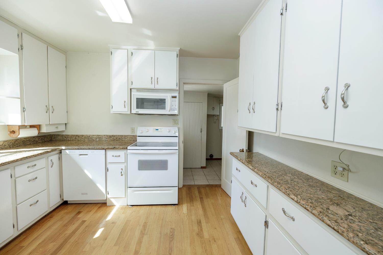 4541 North Gratton Road Denair, CA 95316 - Photo 23 of 75 a kitchen with stainless steel appliances granite countertop a stove and white cabinets