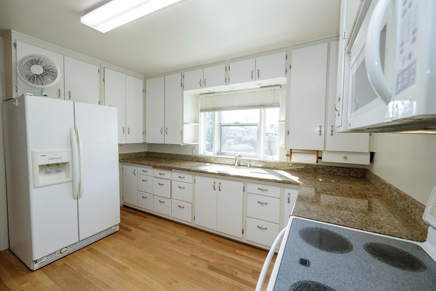 4541 North Gratton Road Denair, CA 95316 - Photo 26 of 75 a kitchen with granite countertop a sink a refrigerator a window and cabinets