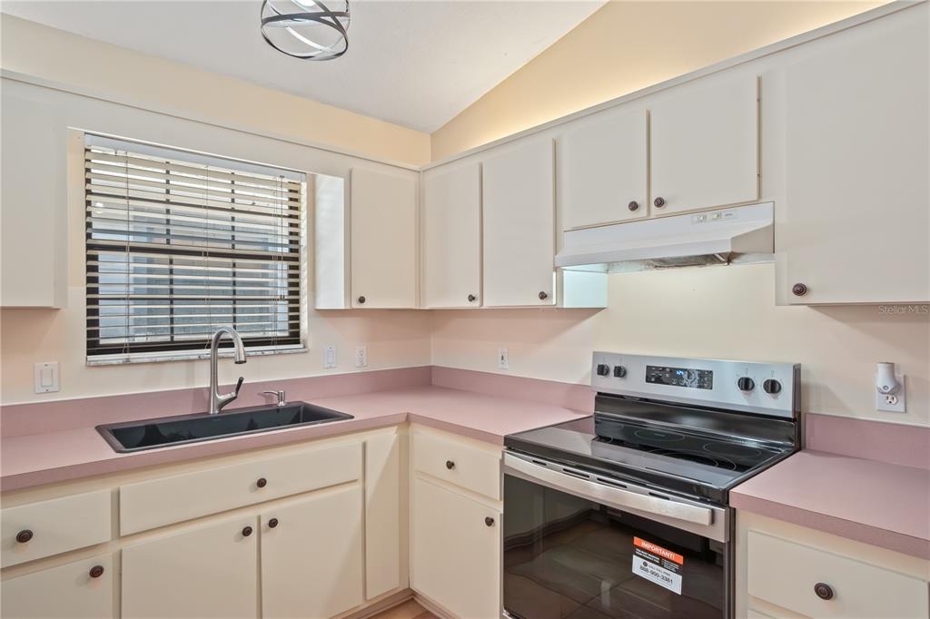 3911 Northeast 22nd Street Ocala, FL 34470 - Photo 12 of 46 a kitchen with granite countertop a sink a stove and cabinets