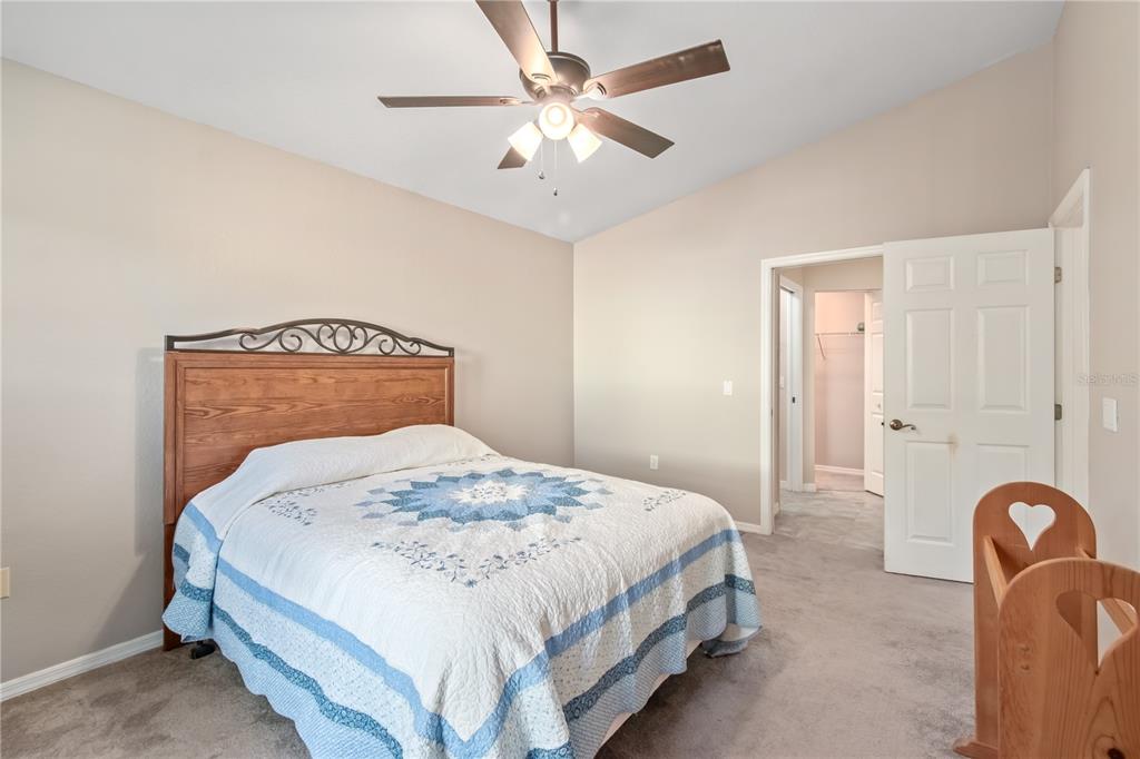 3911 Northeast 22nd Street Ocala, FL 34470 - Photo 21 of 46 a bedroom with a bed and a chandelier