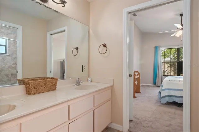 a en suite bathroom with a granite countertop sink and a mirror