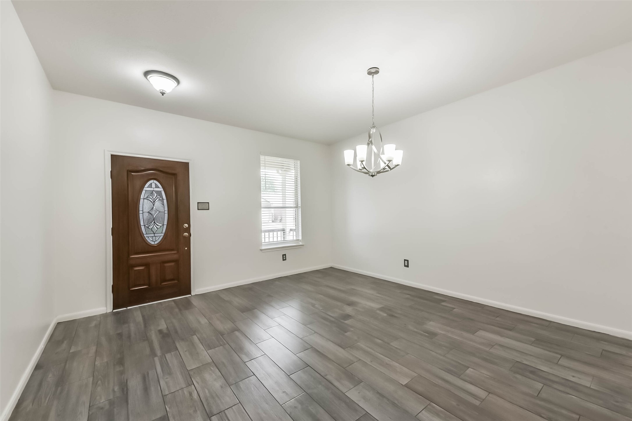 10114 Sand Tracks Court Houston, TX 77064 - Photo 16 of 49 an empty room with wooden floor chandelier and windows
