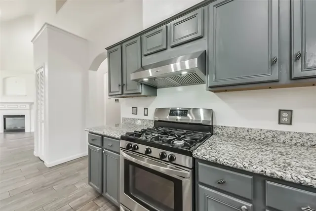 a kitchen with stainless steel appliances granite countertop a stove and a wooden cabinets