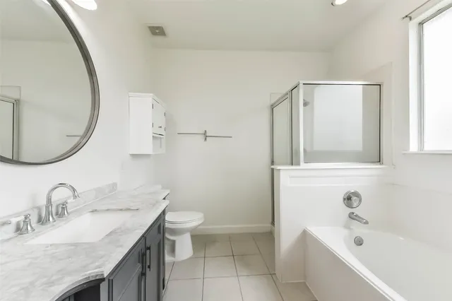 a bathroom with a granite countertop sink mirror and a bathtub