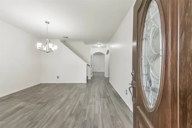 a view of a livingroom with wooden floor and chandelier