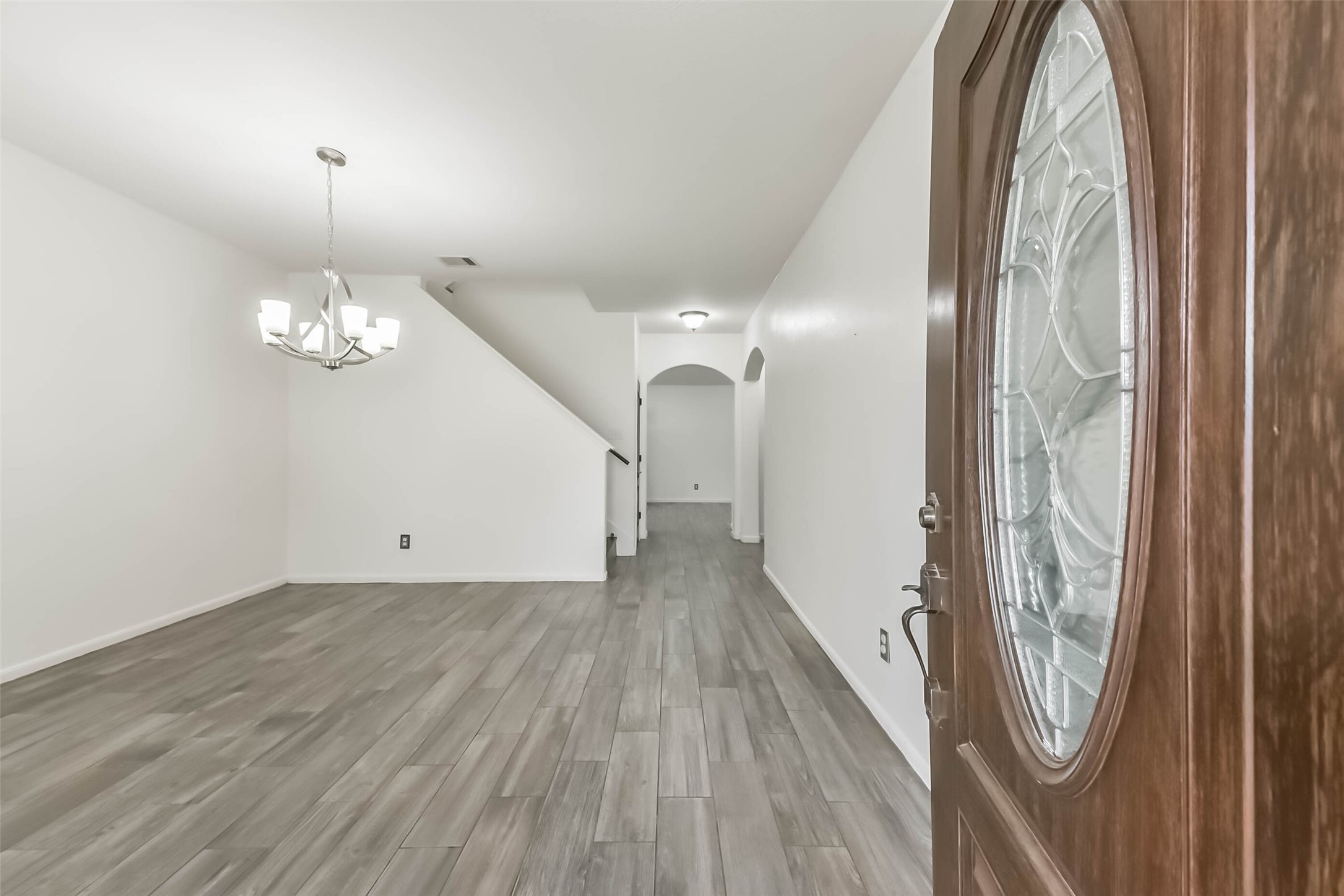 10114 Sand Tracks Court Houston, TX 77064 - Photo 6 of 49 a view of a livingroom with wooden floor and chandelier