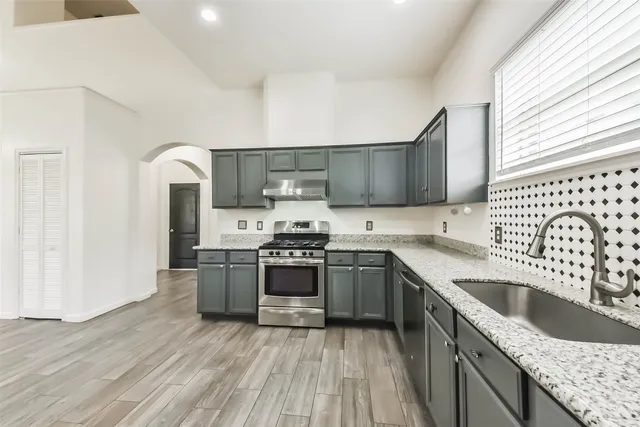 a kitchen with stainless steel appliances granite countertop a sink stove and refrigerator