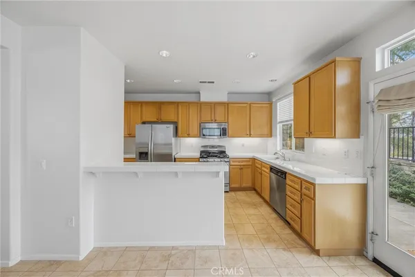 a view of a kitchen with sink and dishwasher cabinet with wooden floor