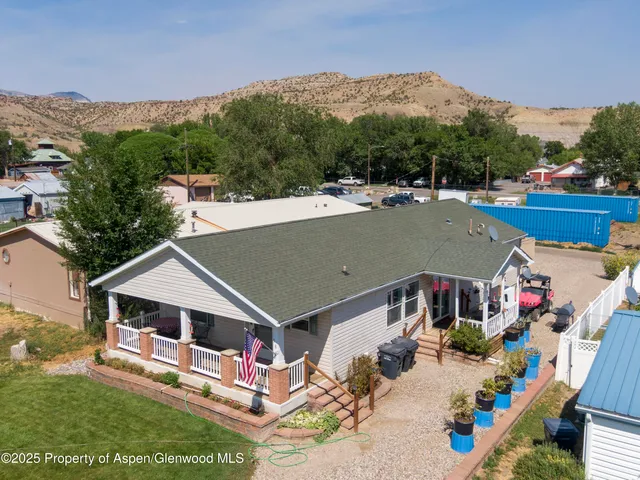 an aerial view of a house roof deck and tall trees