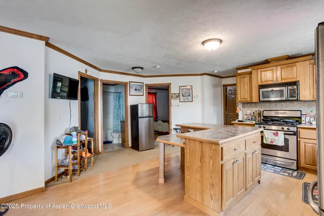 a kitchen with stainless steel appliances granite countertop a refrigerator sink and stove