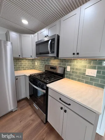 a kitchen with stainless steel appliances granite countertop a sink a stove a microwave and cabinets