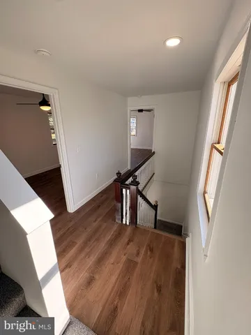 a view of a livingroom with wooden floor and furniture