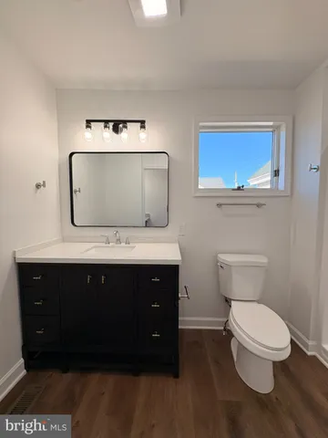a bathroom with a toilet a sink and mirror