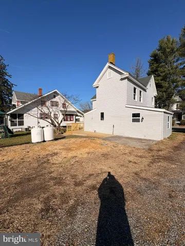 a view of a large white house with a yard