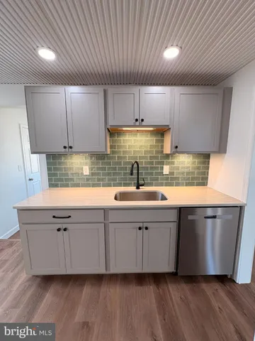 a kitchen with stainless steel appliances granite countertop a sink a stove a refrigerator and cabinets