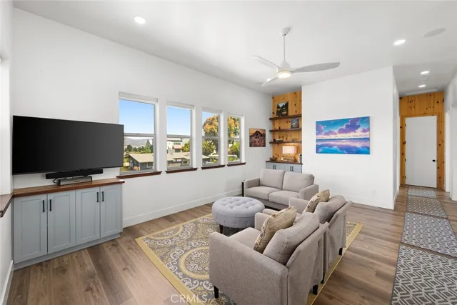 a living room with furniture and a large window with kitchen view