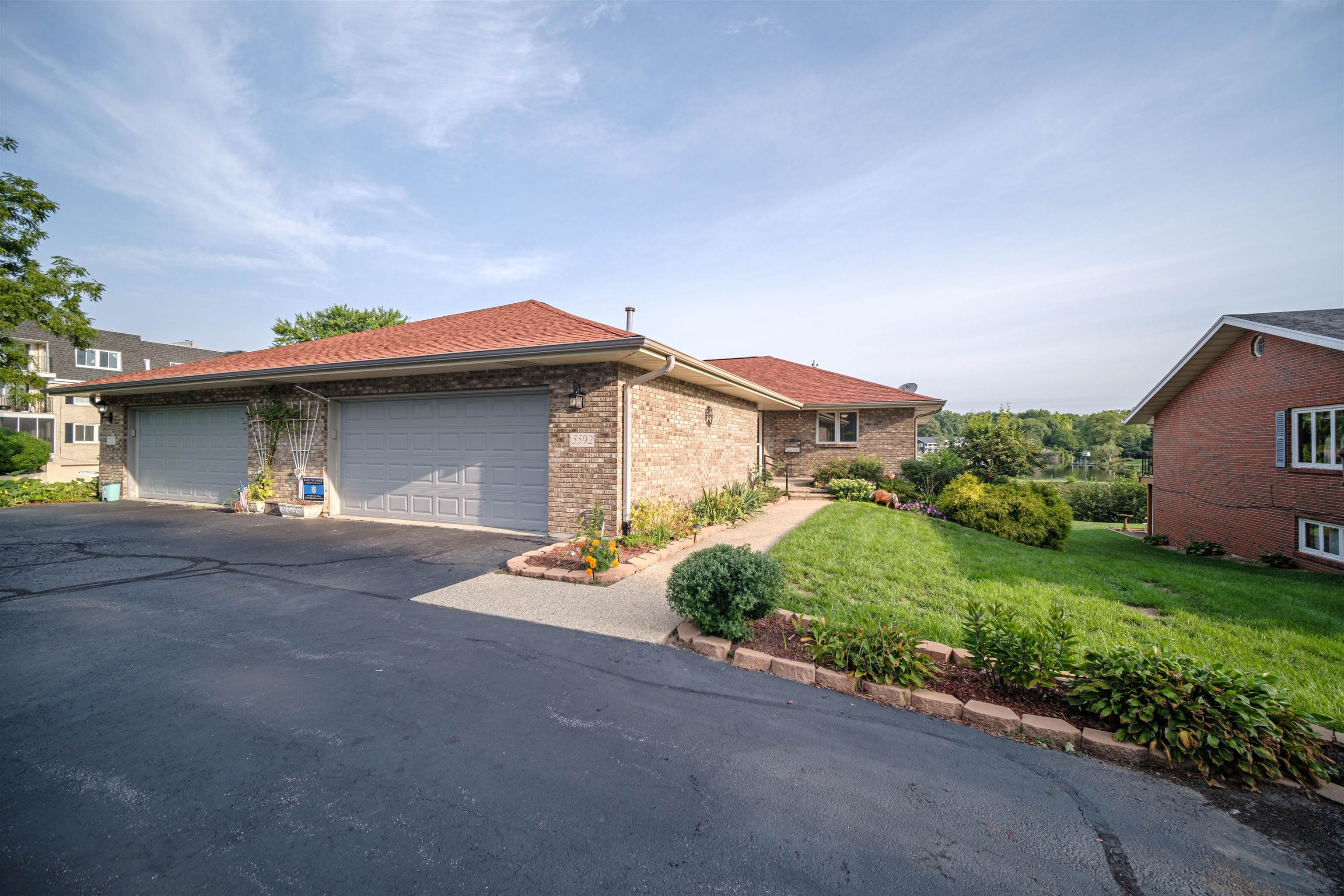 5592 Spring Brook Road Rockford, IL 61114 - Photo 1 of 53 a front view of a house with a yard and garage