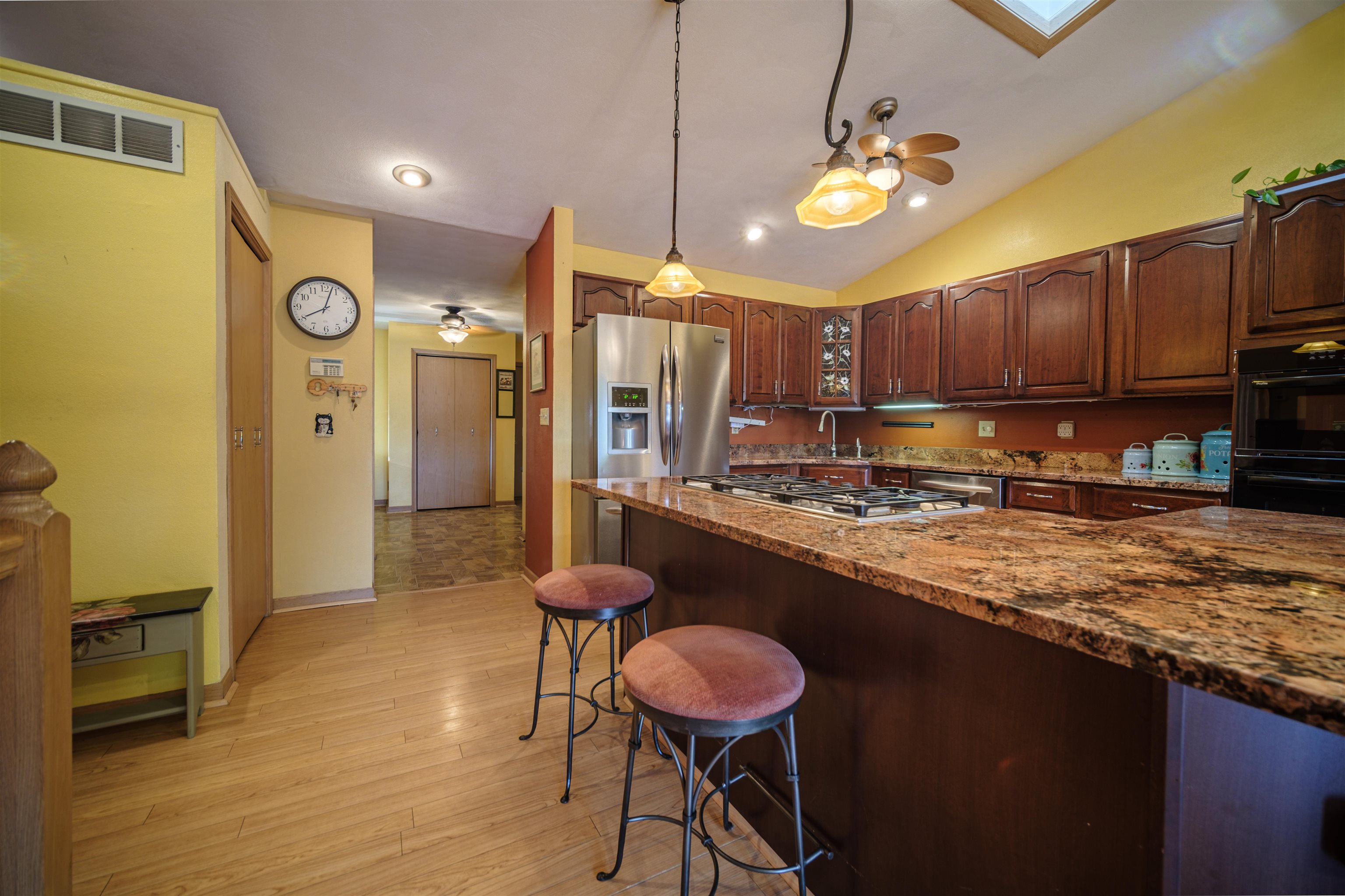 5592 Spring Brook Road Rockford, IL 61114 - Photo 20 of 53 a kitchen with stainless steel appliances granite countertop a stove a refrigerator a sink a dining table and chairs with wooden floor