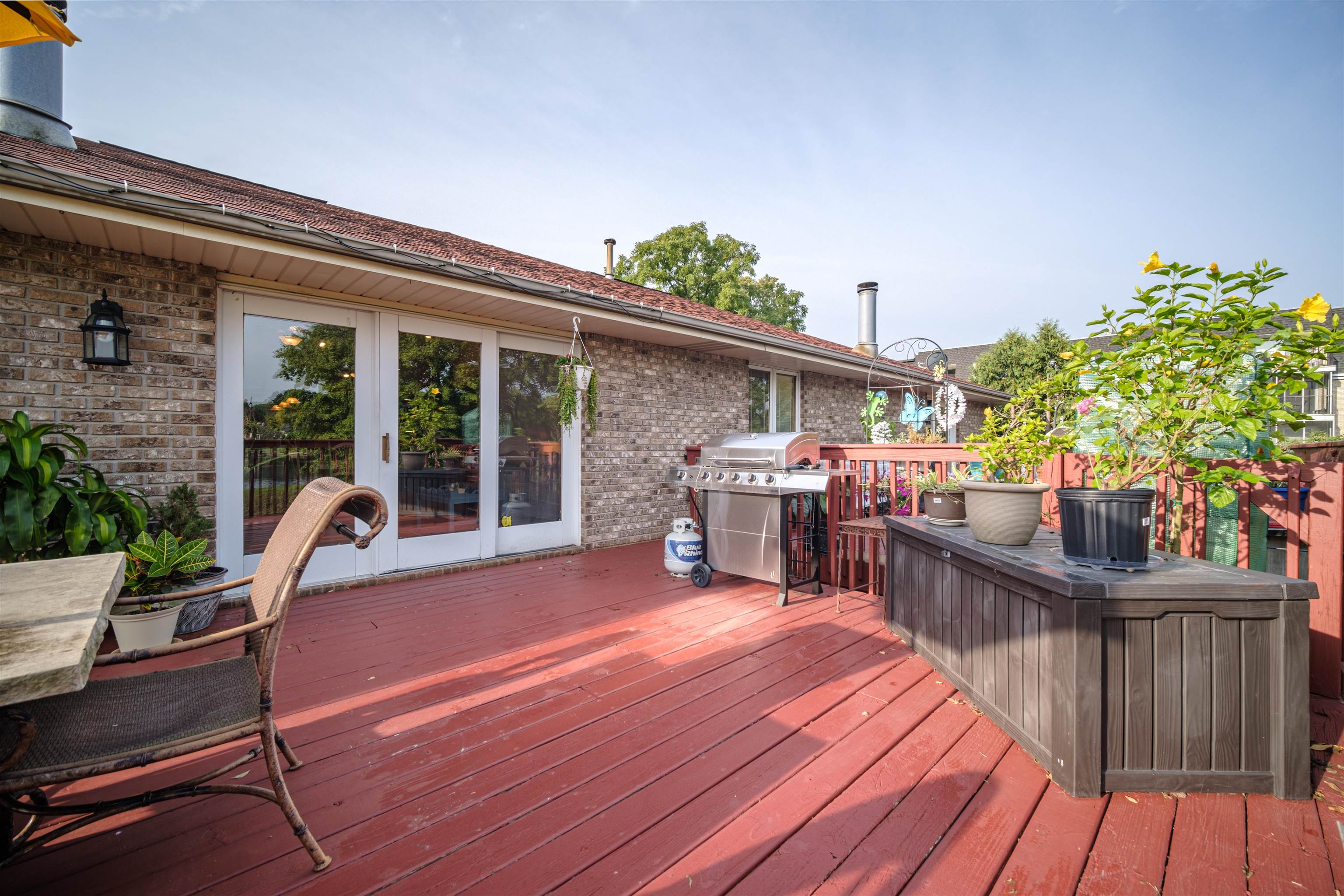 5592 Spring Brook Road Rockford, IL 61114 - Photo 38 of 53 a view of a patio with table and chairs potted plants with wooden floor and fence