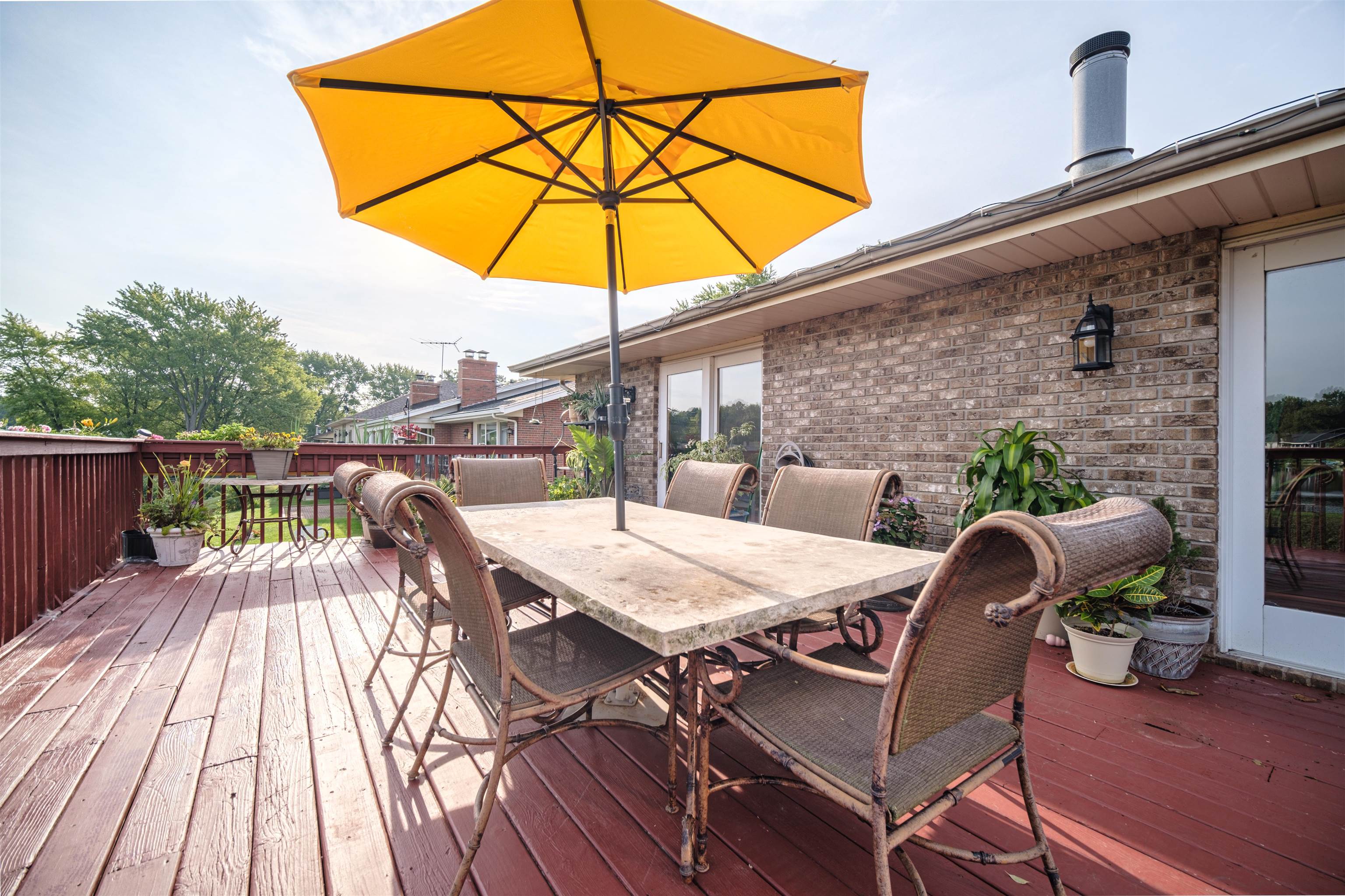 5592 Spring Brook Road Rockford, IL 61114 - Photo 41 of 53 a view of a roof deck with table and chairs under an umbrella with wooden floor