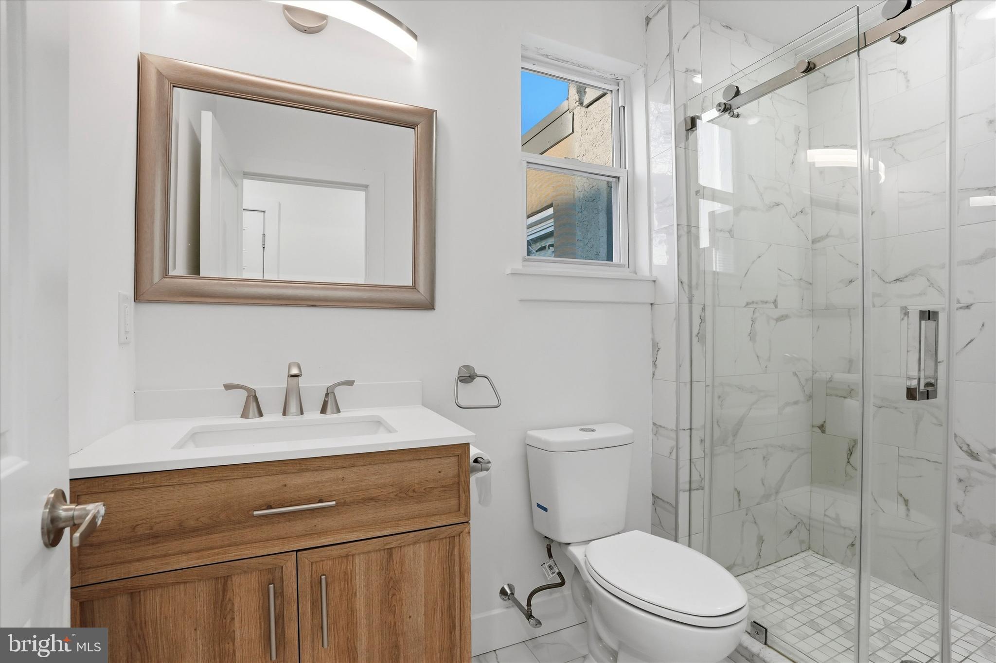 2104 North 8th Street, Unit 3 Philadelphia, PA 19122 - Photo 11 of 15 a bathroom with a toilet sink a mirror and shower