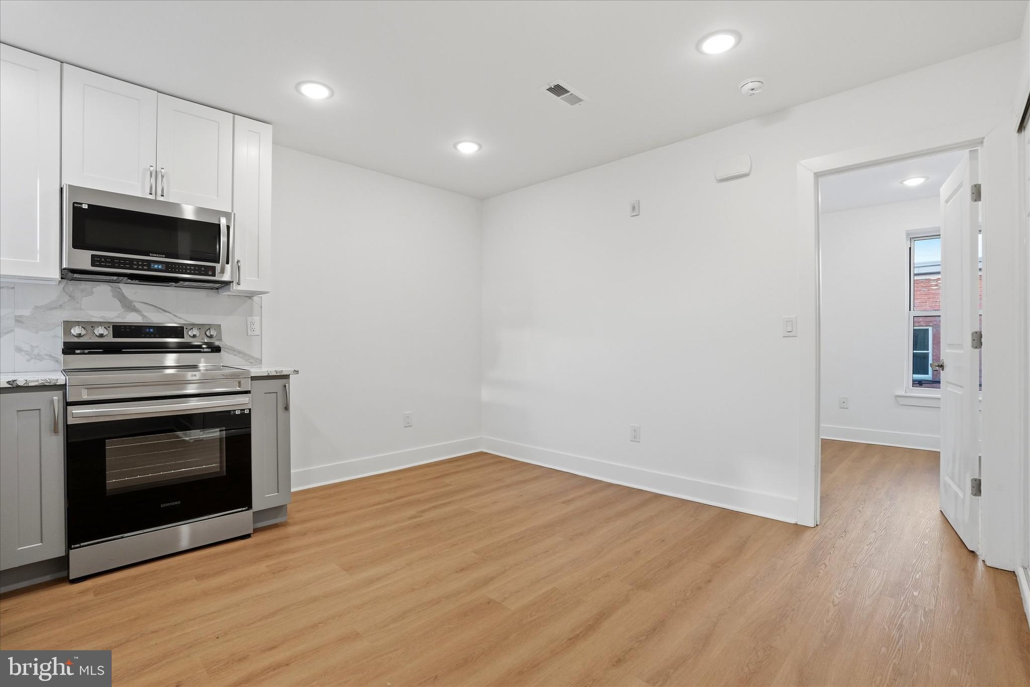 2104 North 8th Street, Unit 3 Philadelphia, PA 19122 - Photo 2 of 15 a view of kitchen with wooden floor electronic appliances and window